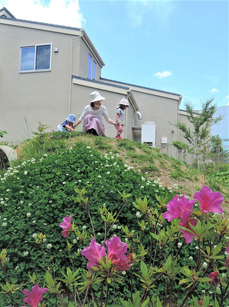 園庭のお山で遊ぶ子どもたち